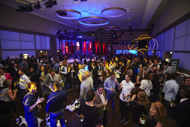 Party im Goldsaal mit zentraler runder Bar und blau-roter Partybeleuchtung.