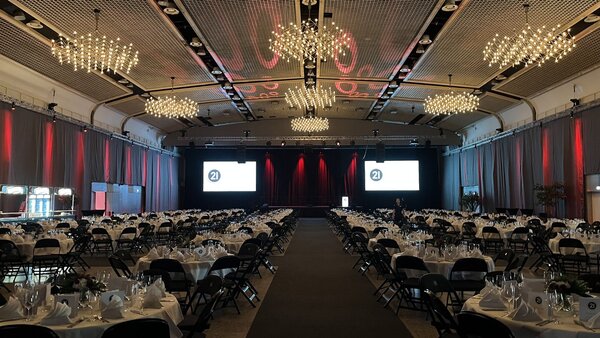 Galabestuhlung in Halle 1 der Messe Dortmund zur Jubiläumsfeier von DSW21, ergänzt durch eine stimmungsvoll beleuchtete Seitenabhängung.